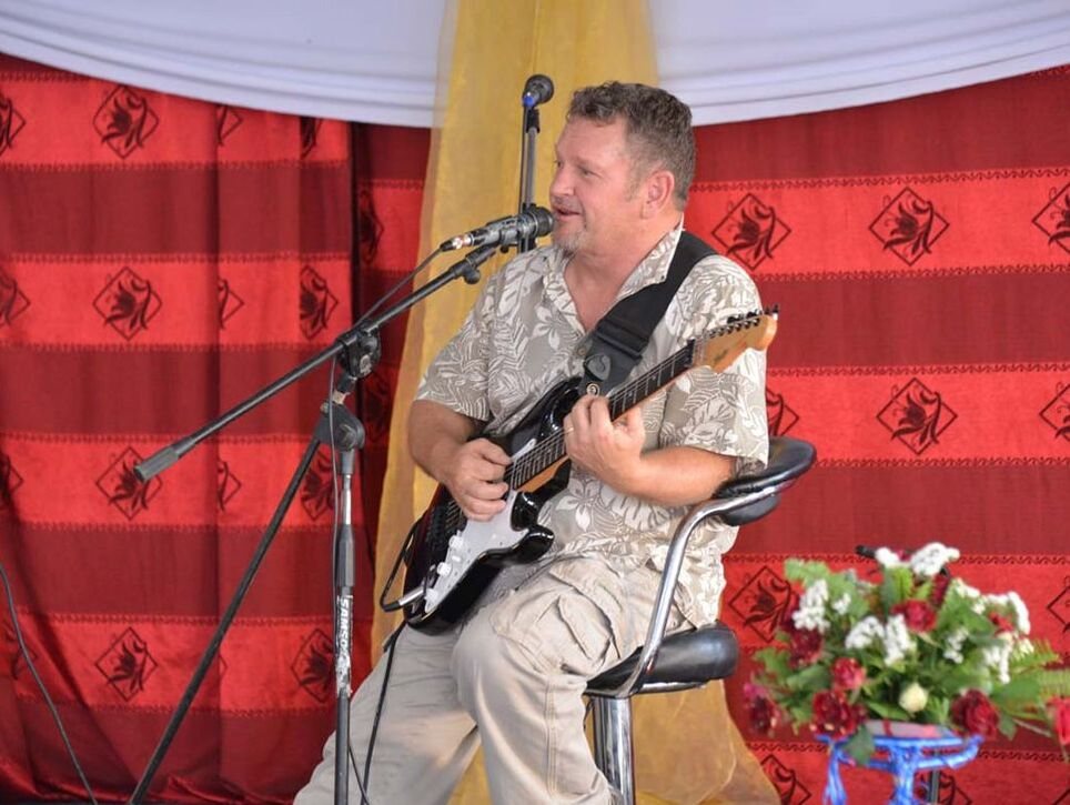 Rich Young playing guitar at a concert in Zambia