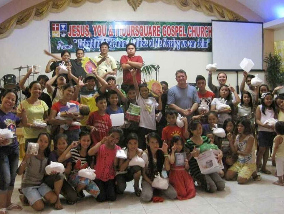 A Pure Works mission team in front of a banner in Manila