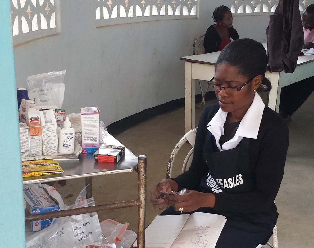 A nurse at a clinic desk with a few bottles of medicine