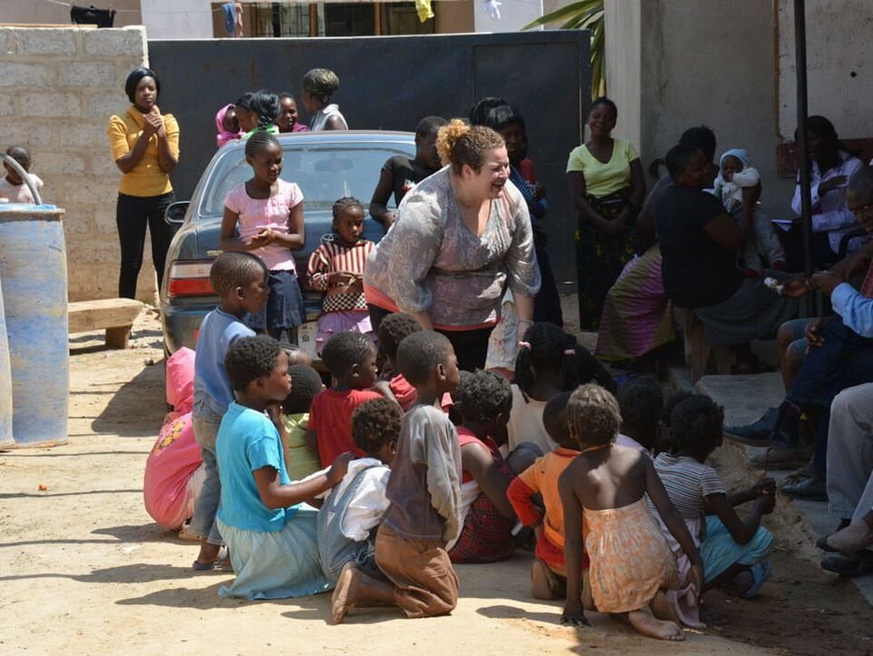 Children and families gathered outdoors at a mission event