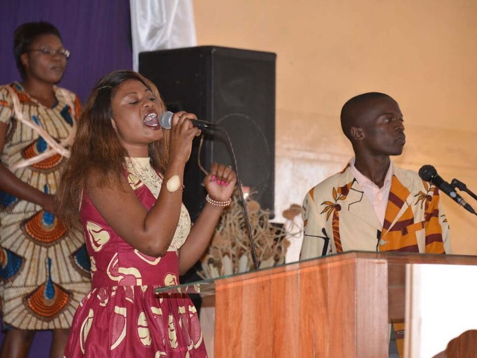 A worship leader at a podium during a praise seminar