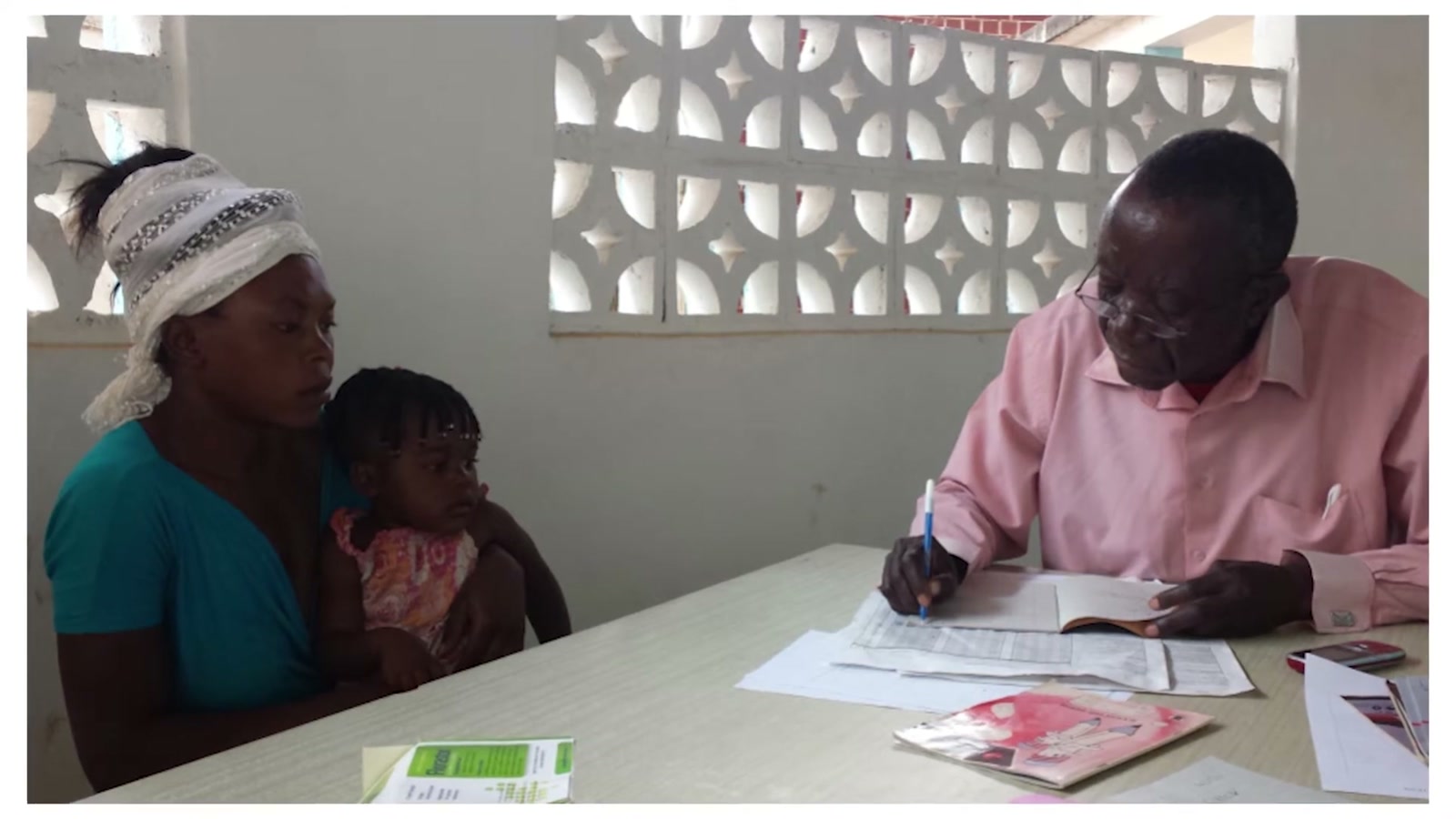 A mother and child at a clinic intake table in Zambia